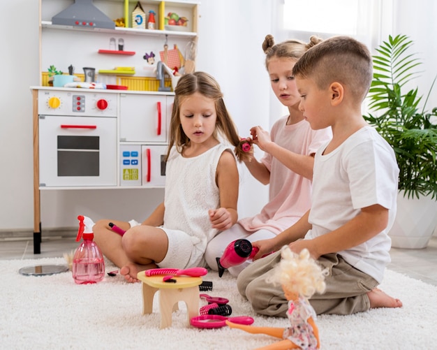 Niños no binarios jugando juntos un juego de salón de belleza.