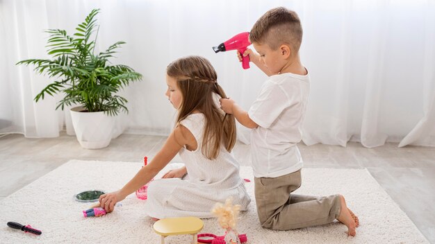 Niños no binarios jugando juntos un juego de salón de belleza.