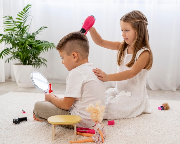 Foto gratuita niños no binarios jugando juntos un juego de salón de belleza.