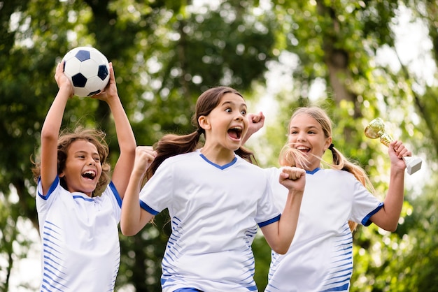 Niños obteniendo un trofeo después de ganar un partido de fútbol al aire libre