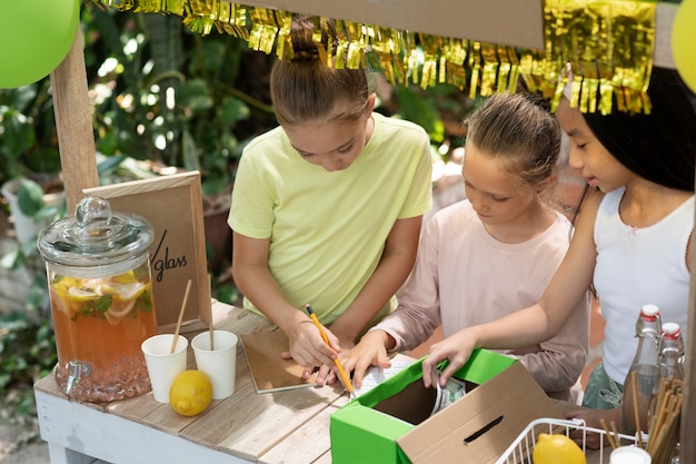 Foto gratuita niños organizando un puesto de limonada