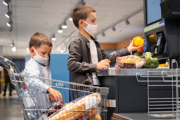 Niños pequeños de compras con máscaras