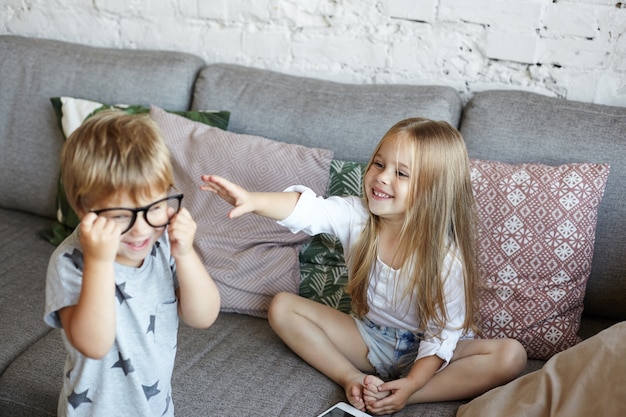 Los niños pequeños felices están jugando en la sala de estar