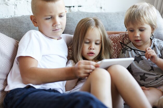 Los niños pequeños felices están jugando en la sala de estar