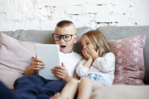 Los niños pequeños felices están jugando en la sala de estar