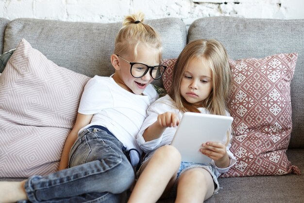 Los niños pequeños felices están jugando en la sala de estar