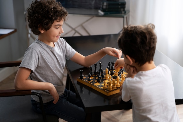 Niños pequeños jugando al ajedrez juntos