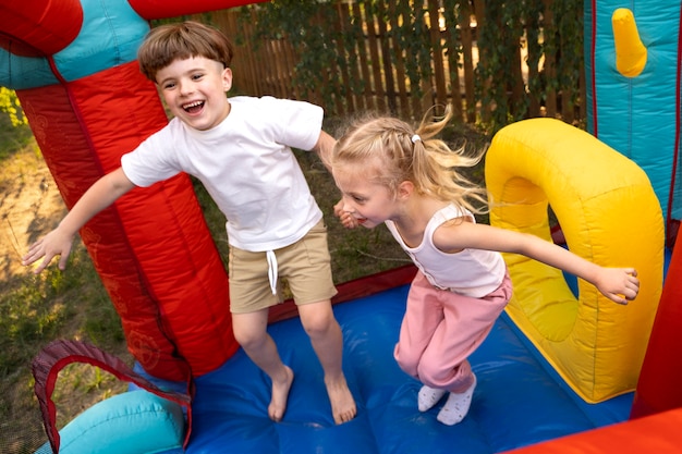 Niños pequeños jugando en la casa de rebote