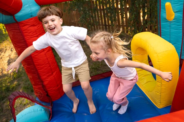 Niños pequeños jugando en la casa de rebote