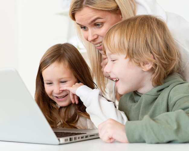 Foto gratuita niños pequeños y madre usando laptop