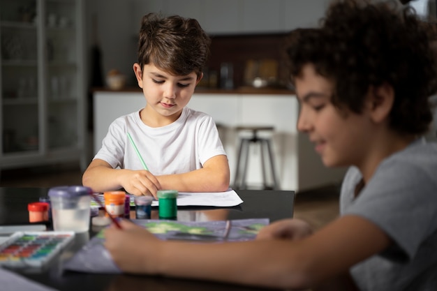 Niños pequeños pintando con acuarela