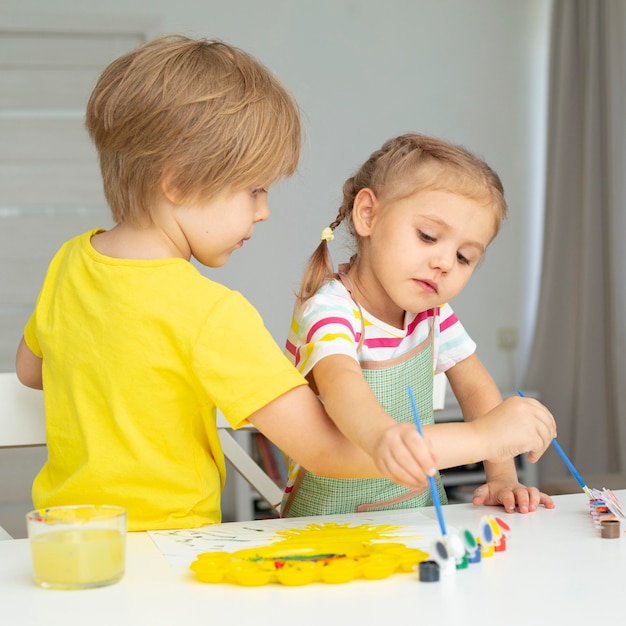 Niños pequeños pintando en casa