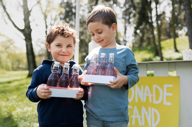 Niños pequeños sonrientes con vista frontal de limonada