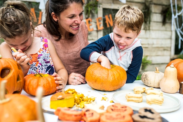 Niños pequeños tallando Halloween jack-o-lanterns