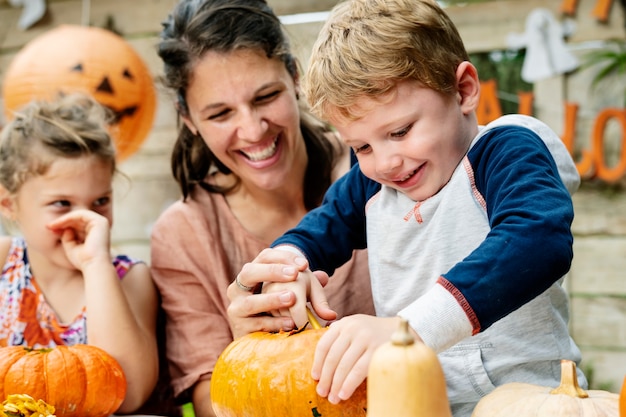 Niños pequeños tallando Halloween jack-o-lanterns