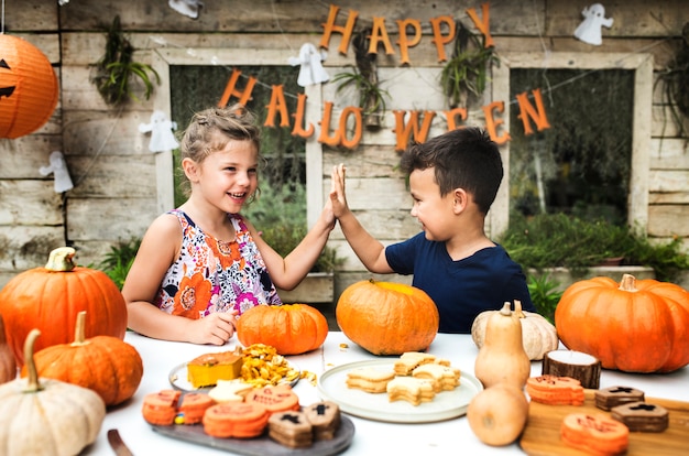 Niños pequeños tallando Halloween jack-o-lanterns