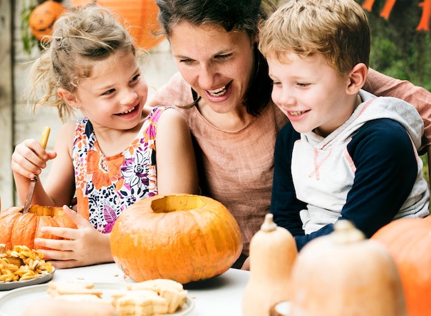 Niños pequeños tallando Halloween jack-o-lanterns