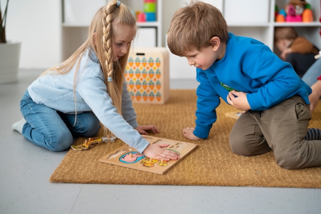 Foto gratuita niños pequeños de tiro completo jugando en el interior