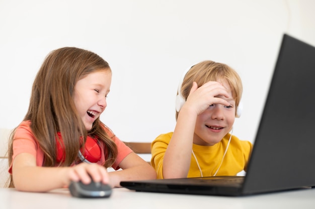 Niños pequeños usando laptop juntos