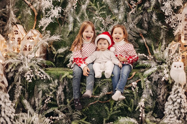 Niños de pie en el nivel superior de la decoración navideña.