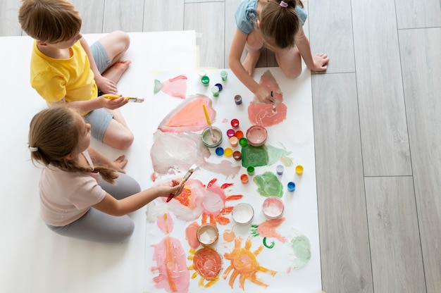 Niños pintando juntos como equipo.