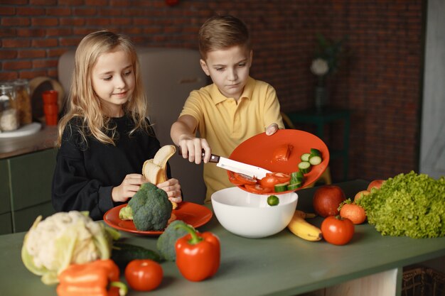 Los niños preparan a salan en una cocina