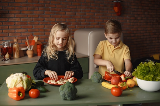 Los niños preparan a salan en una cocina