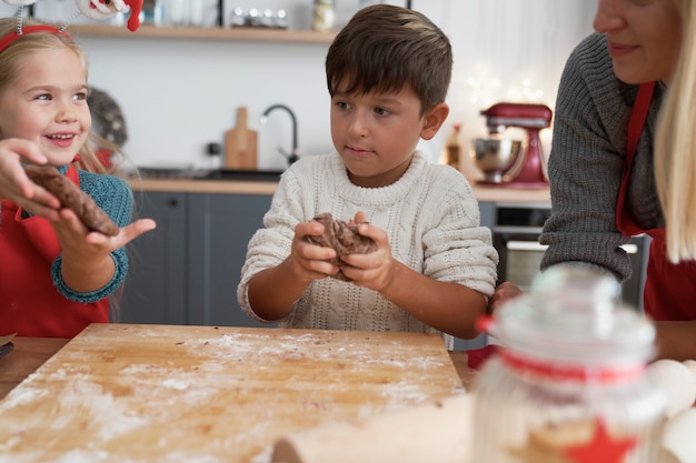 Foto gratuita niños preparando galletas con masa de jengibre