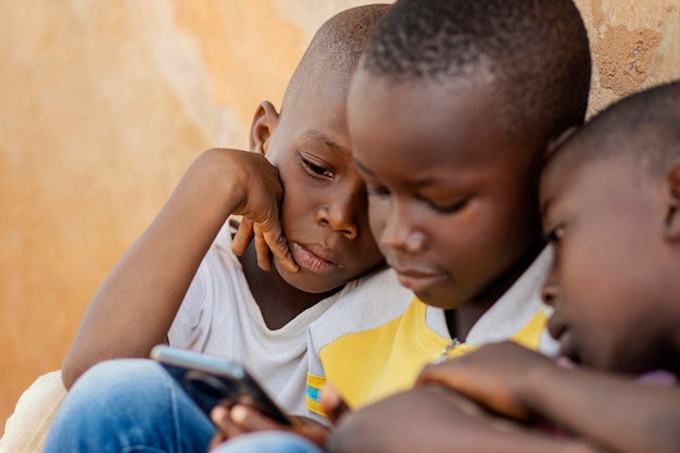 Foto gratuita niños de primer plano mirando smartphone