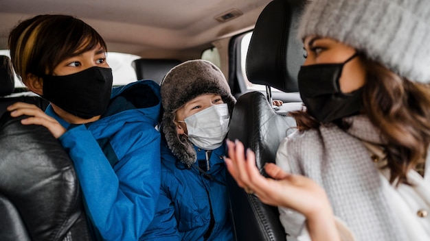 Niños de primer plano y mujer con máscaras