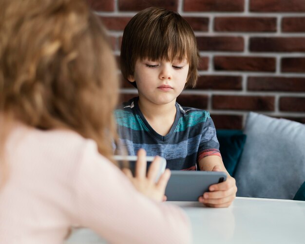 Niños de primer plano con tableta y teléfono