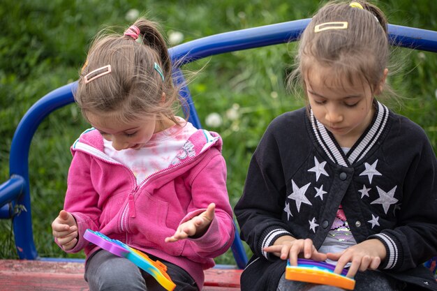 Los niños que juegan con un juguete popular lo hacen estallar, sostienen en sus manos un juego de silicona antiestrés.