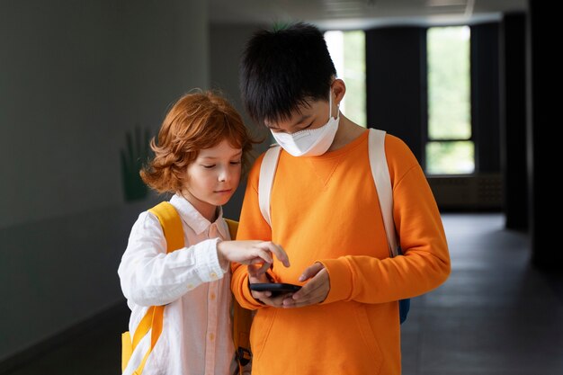 Niños que usan teléfonos inteligentes en la escuela