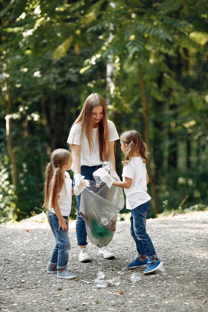Los niños recogen basura en bolsas de basura en el parque