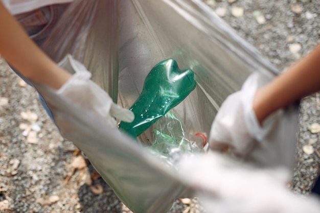 Foto gratuita los niños recogen basura en bolsas de basura en el parque