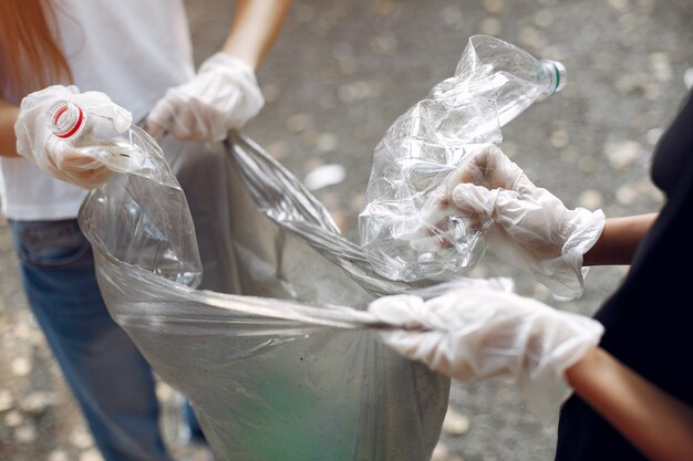 Los niños recogen basura en bolsas de basura en el parque