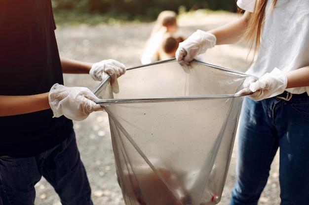 Foto gratuita los niños recogen basura en bolsas de basura en el parque