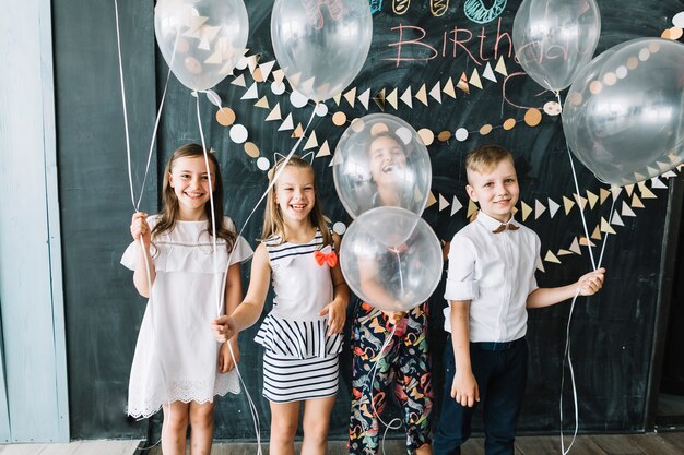 Niños riendo con globos blancos