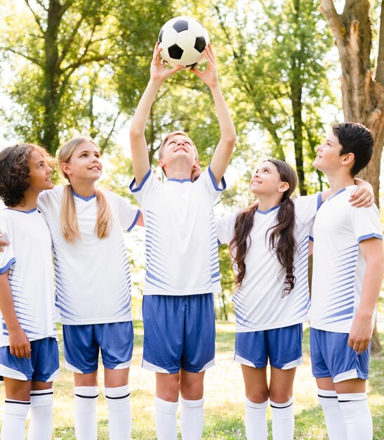 Niños en ropa deportiva jugando al fútbol.