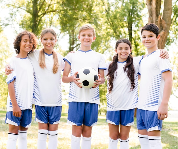 Niños en ropa deportiva jugando al fútbol.