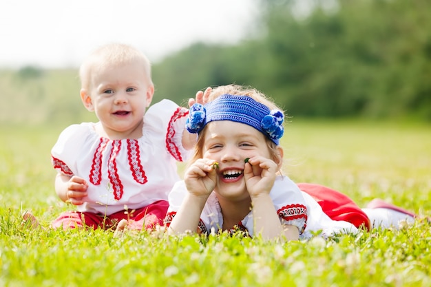 niños en ropa popular sobre hierba