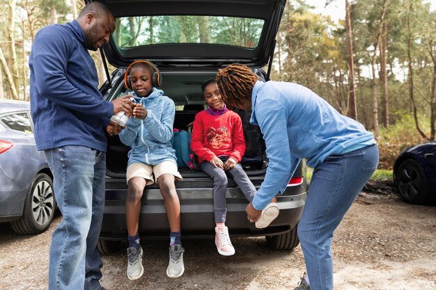 Niños sentados en el maletero de un coche.