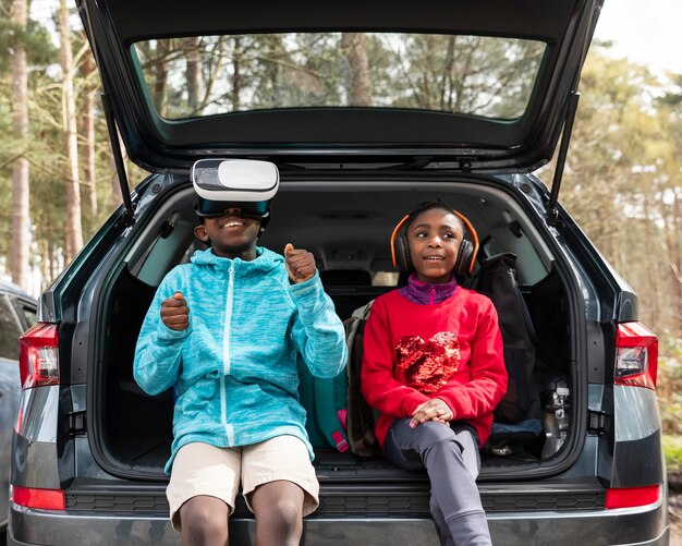 Niños sentados en el maletero de un coche.