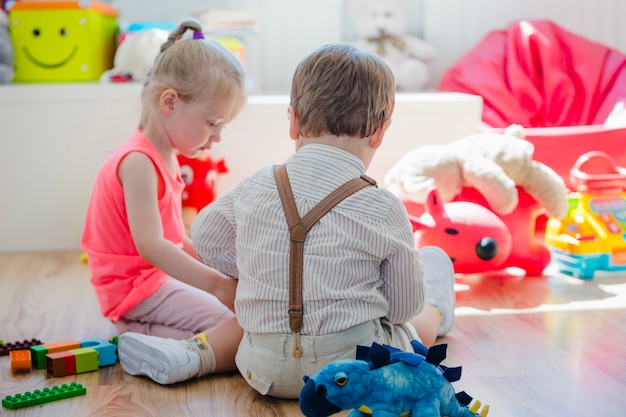 Niños sentados en el piso en la sala de juegos