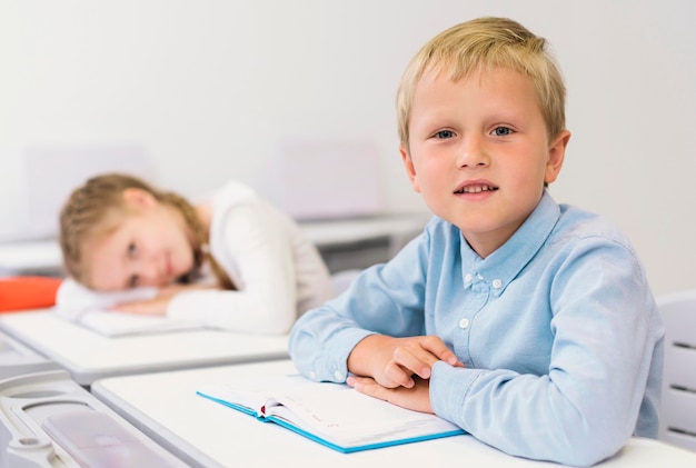 Niños sentados en su escritorio en clase.