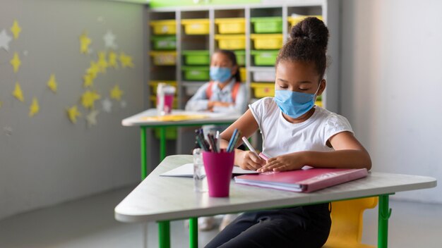 Niños sentados en su escritorio en clase.