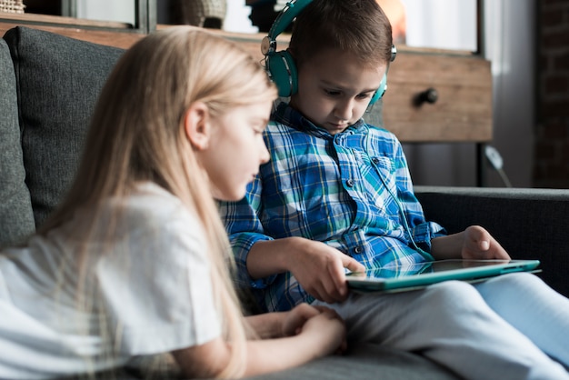 Niños en sofá con tablet