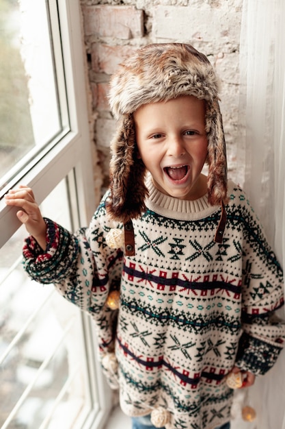 Foto gratuita niños sonrientes de alto ángulo con ropa de abrigo posando