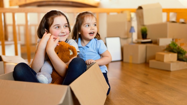 Niños sonrientes con caja y juguetes.