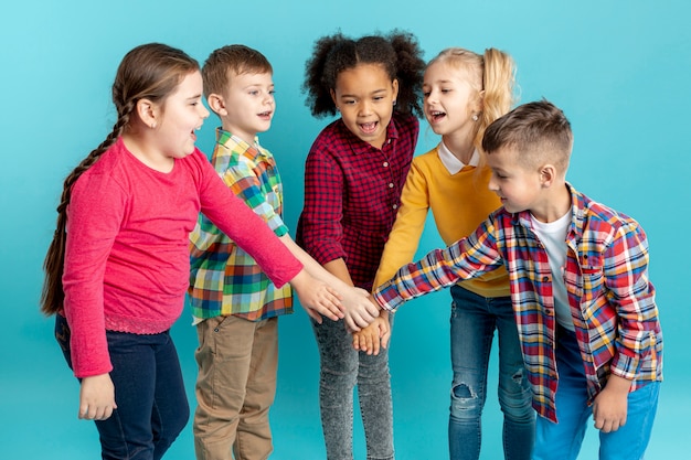 Foto gratuita niños sonrientes haciendo apretón de manos